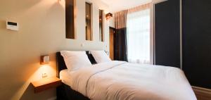una camera da letto con un letto bianco e una finestra di Villa les érables Restaurant Linea a Spa