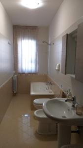 bagno con 2 servizi igienici, lavandino e vasca di Dabliu House a Torrenova
