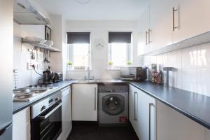 een witte keuken met een wasmachine bij St Vincent Central Apartment in Glasgow