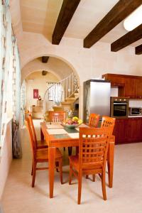cocina y comedor con mesa de madera y sillas en Serkuzan, en Xagħra