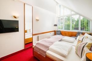 Hotel Blumlage في سيل: غرفة نوم بسرير ونافذة كبيرة