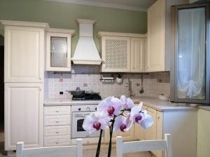 a kitchen with white cabinets and a vase of flowers at Casamare Baldassarri in Civitanova Marche