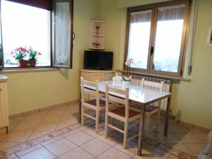 a dining room with a table and chairs and windows at Casamare Baldassarri in Civitanova Marche