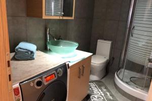 a bathroom with a sink and a washing machine at Hitech Appartment in Amaliás