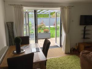 a dining room with a table and a sliding glass door at The Old Stables in Swansea