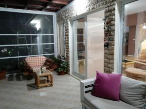 a screened in porch with a couch and a chair at Infinity view villa in Nata