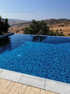 uma grande piscina de água azul com montanhas ao fundo em Infinity view villa em Nata