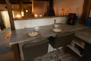 a kitchen counter with two cups and plates on it at Maison Andree in Fresnes-sur-Apance