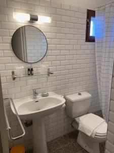 a bathroom with a sink and a toilet and a mirror at Chez Marie in Linguizzetta