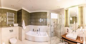 een badkamer met een bad, een toilet en een wastafel bij Liebeskind Boutique Hotel in Krakau