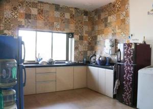 eine Küche mit einem Kühlschrank und einem Fenster in der Unterkunft Dreamy Villa 3Bhk 5 Min Walking Distance Kihim Beach in Alibag
