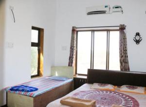 ein Schlafzimmer mit einem Bett und einem großen Fenster in der Unterkunft Dreamy Villa 3Bhk 5 Min Walking Distance Kihim Beach in Alibag