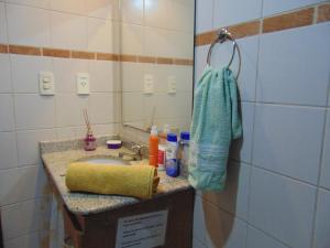 a bathroom with a sink and a mirror at Carnaval Inn Salvador in Salvador