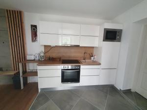 a kitchen with white cabinets and a sink and a stove at VILLA NEAPOLiS in Pécs