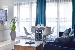 a living room with a couch and a table with chairs at Wronia Business Residence by BookingHost in Warsaw