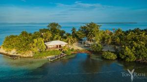 an aerial view of an island in the water at Pelican Beach Resort South Water Caye in Dangriga