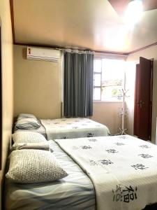 Zimmer mit 3 Betten und einem Fenster in der Unterkunft Hotel Fortaleza Manaus in Manaus
