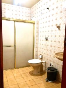 a bathroom with a shower and a toilet and a sink at Hotel Fortaleza Manaus in Manaus