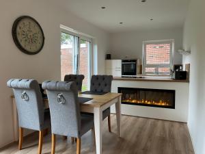 a dining room with a table and a fireplace at Exklusive Ferienwohnungen MEERLIEBE Norddeich in Norddeich