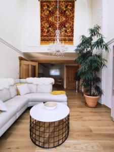 a living room with a white couch and a coffee table at Penzion Lucs in Heľpa