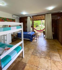 a bedroom with two bunk beds and a patio at ThalassaGarden Hotel - Pousada in Pipa