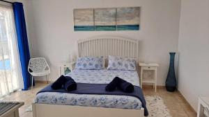 a bedroom with a bed with blue sheets and blue pillows at Villa Essence - a unique detached villa with A-C, heated private pool, hottub, gardens, patios and stunning views! in Tías +23 photos
