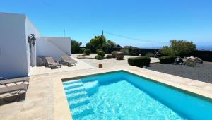 a swimming pool in the backyard of a house at Villa Essence - a unique detached villa with heated private pool, hottub, gardens, patios and stunning views! in Tías