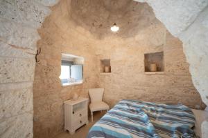 A bed or beds in a room at WePuglia - Trulli Brillina