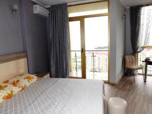 a bedroom with a bed and a large window at Orbi Plaza Apartment in Batumi