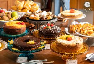 uma mesa cheia de bolos e doces em pratos em Pousada Luis XV em Campos do Jordão