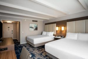 a hotel room with two beds and a desk at Crowne Plaza Albany - The Desmond Hotel in Albany