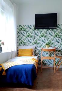 een slaapkamer met een muurschildering van bladeren bij Apartamenty Amarel in Stegna