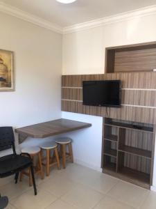 a kitchen with a table and stools and a tv at DiRoma resort Caldas Novas in Caldas Novas