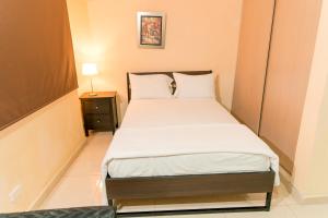 a small bedroom with a bed with white sheets and pillows at Apartamentos Roman in Santo Domingo +56 photos