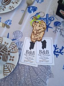 una mesa con dos etiquetas y una galleta en ella en B&B Lago Mulargia, en Siùrgus Donigala