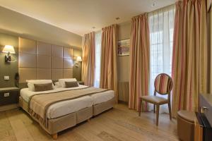 a hotel room with a bed and a chair at Villa Margaux Opéra Montmartre in Paris