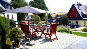 einen Tisch mit 2 Stühlen und einem Sonnenschirm auf einer Terrasse in der Unterkunft Apartments - Lehmanns Ferienwohnungen in Kurort Oberwiesenthal