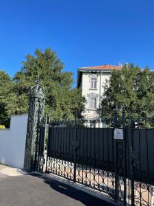 Arcisate的住宿－Villa Sapi，白色房子前面的黑色大门