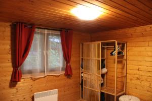 una camera con finestra in una cabina di legno di Chalet Ardennais 240 - La Boverie - Rendeux a Rendeux