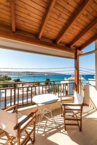 un patio con tavolo, sedie e vista sull'oceano di Simon Studios and Apartments a Sitia