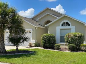 una casa con una palma di fronte di Vacation Homes of Orlando Area a Orlando