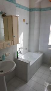 een witte badkamer met een bad en een wastafel bij Napoli Pompei Sorrento Appartamento con Posto Auto in Gragnano