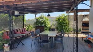 Un patio al aire libre con una mesa y sillas de madera. en El chalet del Mar, en Chiclana de la Frontera