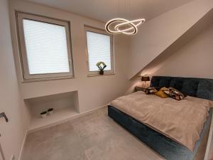 1 dormitorio con 1 cama y 2 ventanas en NADJEZIORNA LUX en Ełk