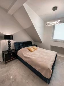1 dormitorio con 1 cama grande y techo en NADJEZIORNA LUX en Ełk