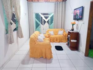 een woonkamer met twee stoelen en een tv bij Salinas praia do atalaia in Salinópolis