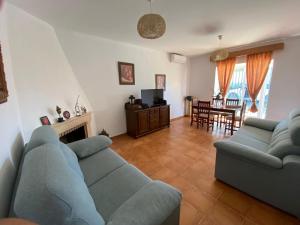 Una sala de estar con dos sofás azules y una mesa. en El chalet del Mar, en Chiclana de la Frontera