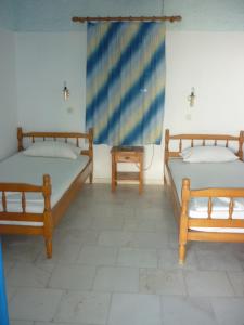 een kamer met 2 bedden en een tafel bij Agios Antonios in Perissa