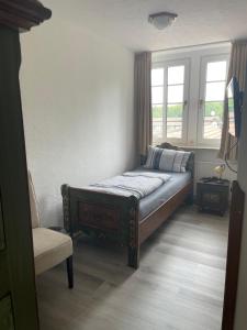 um quarto com uma cama, uma cadeira e uma janela em Hotel & Gastropark Loemühle-Restaurant-Biergarten em Marl