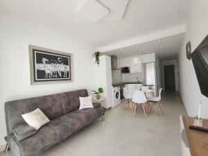 Il comprend un salon avec un canapé et une cuisine. dans l'établissement Apartamento Vero Senator, Costa Teguise, à Costa Teguise